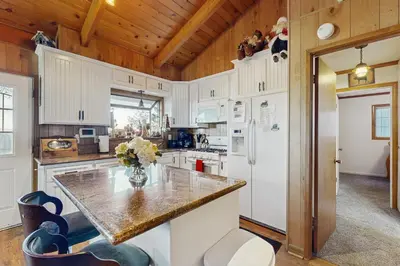 a kitchen with white cabinets and a marble counter top at Lakeside Serenity in Crestline