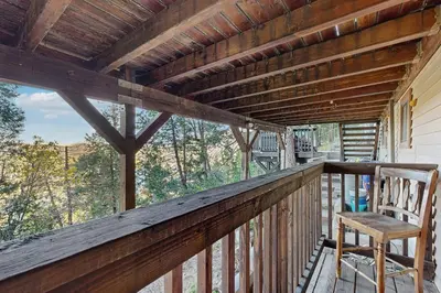 a wooden porch with a rocking chair on a deck at Lakeside Serenity in Crestline