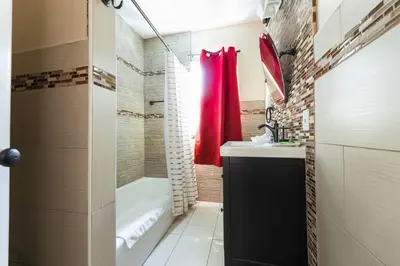 a bathroom with a red shower curtain and a sink at Charming LA 2 Bedroom For Your Home Away From Home in Los Angeles