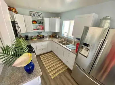 a kitchen with white cabinets and a stainless steel refrigerator at Hidden Gem LA 2bd house with dreamy backyard in Encino