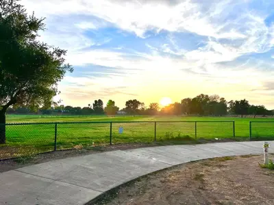 a sunset over a field with a fence and a road at Sweet Tuscan Dreams-Private Entrance & Bathroom with Patio in Encino