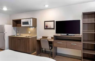 a kitchen with a desk with a tv and a refrigerator at Extended Stay America Suites - Norco in Norco