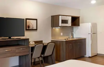 a kitchen with a table with chairs and a refrigerator at Extended Stay America Suites - Norco in Norco