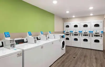 a laundry room with white machines and green walls at Extended Stay America Suites - Norco in Norco