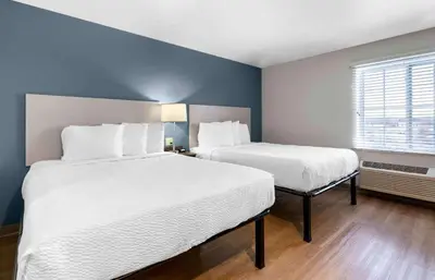 two beds in a small room with blue walls at Extended Stay America Suites - Redlands in Redlands