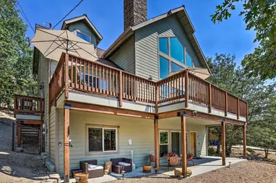 a house with a wrap around porch with a deck at The Zen Playhouse with Lake Arrowhead Access! in Lake Arrowhead