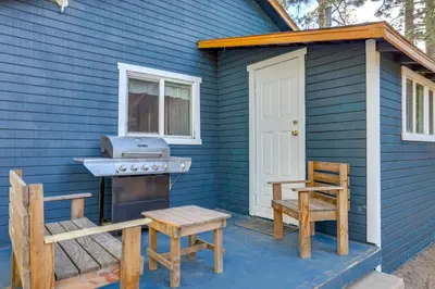 a blue house with a grill and a bench and a chair at Grizzly Pine Cottage - Walk to Ski Beach Park! in Big Bear Lake
