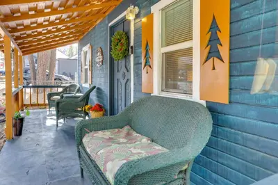 a green couch sitting on the porch of a house at Grizzly Pine Cottage - Walk to Ski Beach Park! in Big Bear Lake