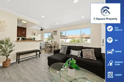 a living room with a black couch and a table at Sunny & Cheerful Near I-10 Queen Beds w Parking! in Alhambra