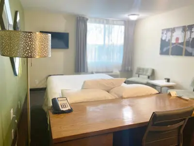 a bedroom with a bed and a table with a telephone at Redac Gateway Hotel Torrance in Torrance
