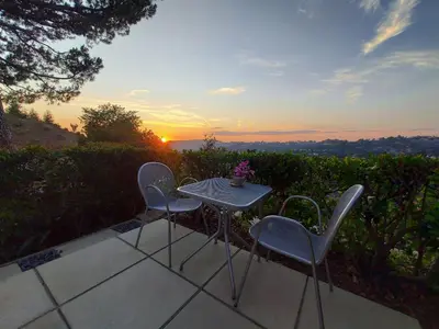 a table and chairs on a patio with the sunset at Silver Box Beverly Hills in Los Angeles