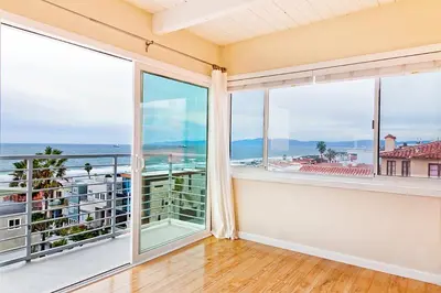 an empty room with large windows with a view of the ocean at Beautiful Views - Sand Section of Manhattan Beach 2 Bed/2 Bath in Manhattan Beach