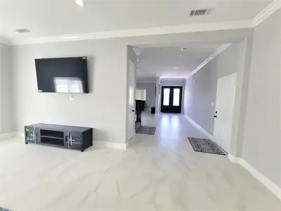 a white living room with a television on a wall at Huge Family Home Near Disneyland & SoCal Beaches in Midway City