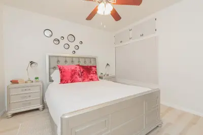 a bedroom with a white bed with a red pillow at Cool and Cozy Pad Close to Everything in Los Angeles