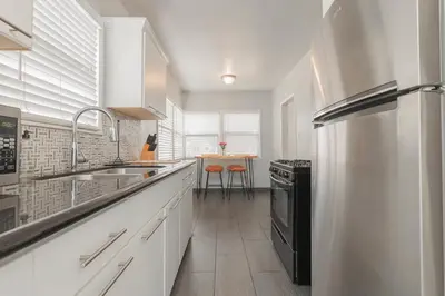 a kitchen with white cabinets and a black refrigerator at Cool and Cozy Pad Close to Everything in Los Angeles