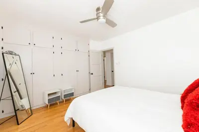 a white bedroom with a bed and a ceiling fan at Inviting Home in Historic Leimert Park in Los Angeles