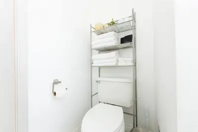 a bathroom with a white toilet and towels at Inviting Home in Historic Leimert Park in Los Angeles