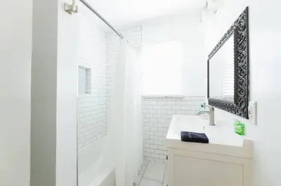 a white bathroom with a sink and a shower at Inviting Home in Historic Leimert Park in Los Angeles