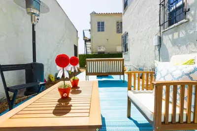 a wooden table with red flowers on a patio at Spring Charmer In The Heart Of The City in Los Angeles