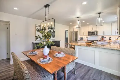a kitchen and dining room with a wooden table and chairs at Chic Lake House with Furnished Deck and Hot Tub! in Lake Arrowhead