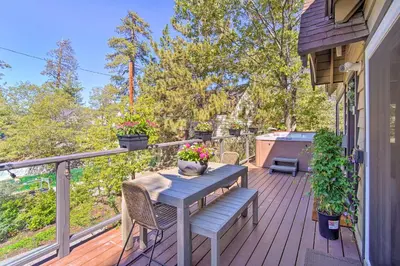 a wooden deck with a table and a bench on it at Chic Lake House with Furnished Deck and Hot Tub! in Lake Arrowhead