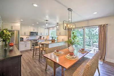 a kitchen and dining room with a table and chairs at Chic Lake House with Furnished Deck and Hot Tub! in Lake Arrowhead