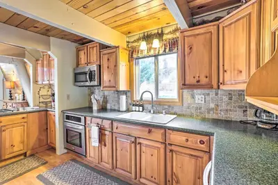 a kitchen with wooden cabinets and a sink at Château Forêt in Big Bear with Hiking Trail Access in Big Bear City