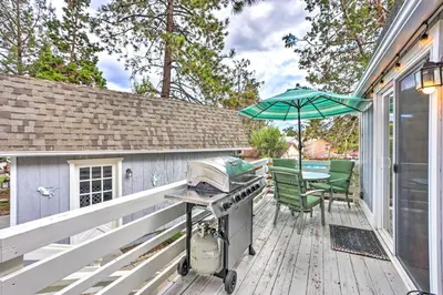 a grill on a deck with a table and an umbrella at Château Forêt in Big Bear with Hiking Trail Access in Big Bear City