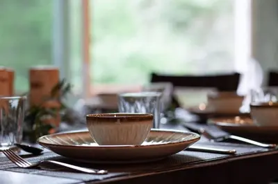 a table with plates and bowls and glasses on it at Hillside Hideaway - game rm - master spa - Luxury in Lake Arrowhead