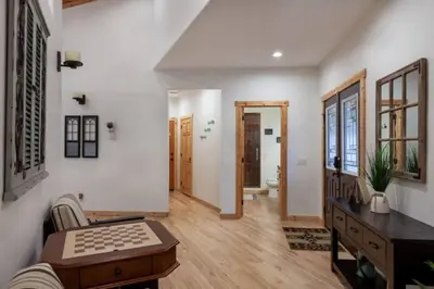 a living room with white walls and wooden floors at Hillside Hideaway - game rm - master spa - Luxury in Lake Arrowhead