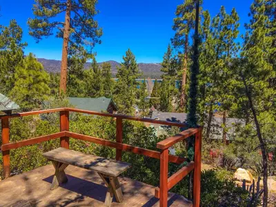 a wooden bench sitting on top of a deck at ITH Big Bear Lake Hostel & Lodge in Big Bear Lake