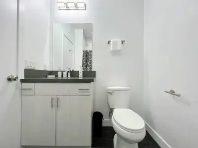 a white bathroom with a toilet and a sink at 4BR Townhouse in KoreaTown in Los Angeles