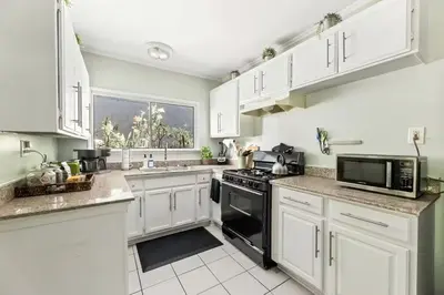 a kitchen with white cabinets and a black stove top oven at Echo Park Hills - Walk to Dodger Stadium - Near DTLA SoFi in Los Angeles