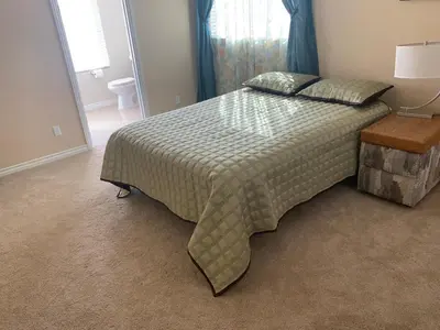 a bedroom with a large bed with a blanket on it at High End Triplex with Pool in Riverside