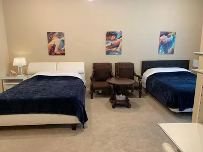 a bedroom with two beds and a chair and a table at High End Triplex with Pool in Riverside