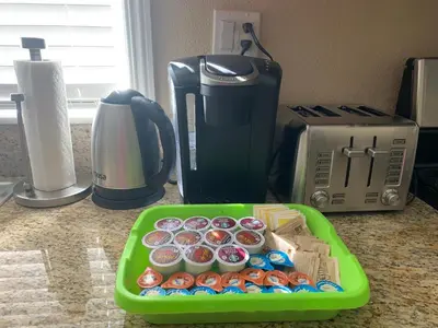 a green tray filled with donuts in front of a coffee maker at High End Triplex with Pool in Riverside