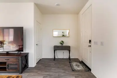 a hallway with a table and a door with a mirror at Spacious Modern Home in Sierra Lakes Fontana in Fontana