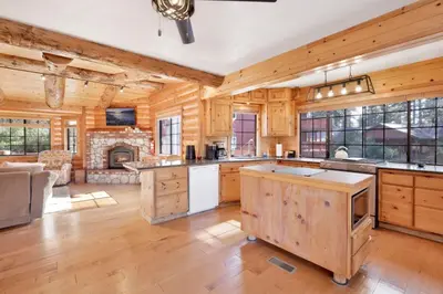 a large kitchen with wooden walls and a fireplace at The Alps Lodge #2142 by Big Bear Vacations in Big Bear Lake