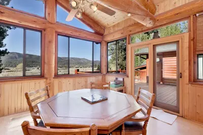 a dining room with a table and chairs and windows at The Alps Lodge #2142 by Big Bear Vacations in Big Bear Lake