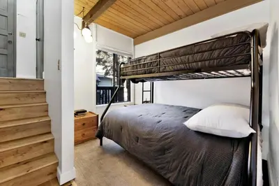 a bedroom with a bunk bed and a staircase at Switzerland Slopes #2125 by Big Bear Vacations in Big Bear Lake