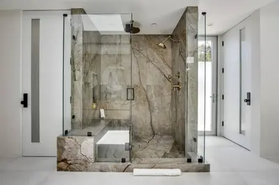 a bathroom with a shower with a stone wall at Vista Modern in Los Angeles