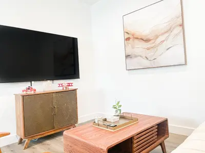 a living room with a tv and a coffee table at Cozy Habitat in Los Angeles