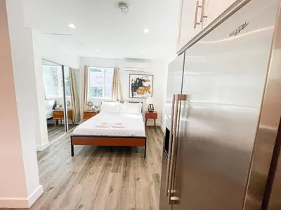a bedroom with a bed and a refrigerator at Cozy Habitat in Los Angeles