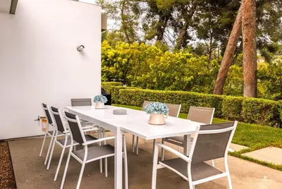a white dining table and chairs in a yard at Vue Modern in Los Angeles