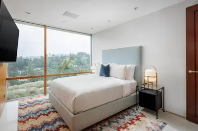 a bedroom with a large bed and a large window at Vue Modern in Los Angeles