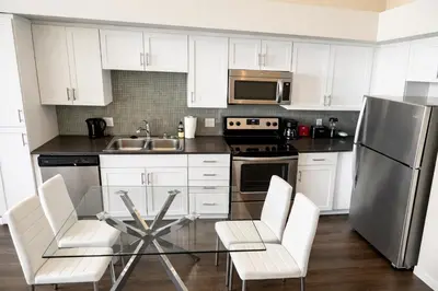 a kitchen with white cabinets and a stainless steel refrigerator at Luxury Residence Loft 3 Beds with Pool and Gym in Los Angeles