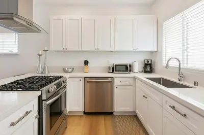 a kitchen with white cabinets and a stove top oven at Exclusive 2BD 3BA with Balcony in Los Angeles