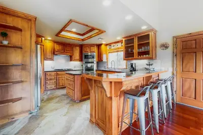 a kitchen with wooden cabinets and a island with bar stools at Deer Mountain in Lake Arrowhead