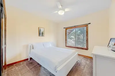 a white bedroom with a bed and a window at Deer Mountain in Lake Arrowhead