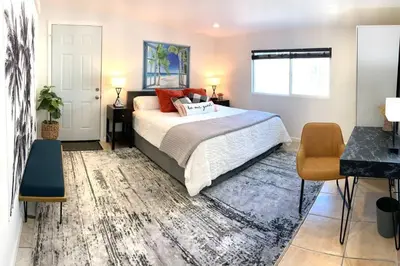 a bedroom with a bed and a table and a window at King Garden Suite - 10 mins to Beach and LAX in Gardena
